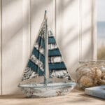 Dekorativ segelbåt i trä med segel i textil, mått 38,5x25,5x6,5 cm (hxlxb).