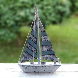 Dekorativ segelbåt i trä med segel i textil, mått 38,5x25,5x6,5 cm (hxlxb).