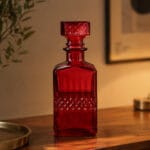 Elegant röd karaff i glas med slipad dekor och dekorativ kork. Fin för snaps, likör eller whisky vid fest och högtider. Höjd 23,5 cm.
