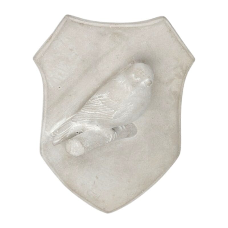Väggdekoration i betong formad som en sköld med fågel i relief. Lugn och dekorativ detalj för väggen. Mått 18x13x6 cm.