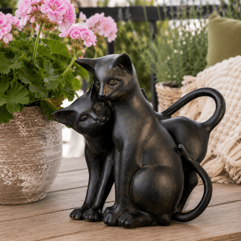 Dekorativ skulptur med två sittande katter i polyresin. Elegant kattfigur med mörk patinerad finish för hem, uterum eller altan.