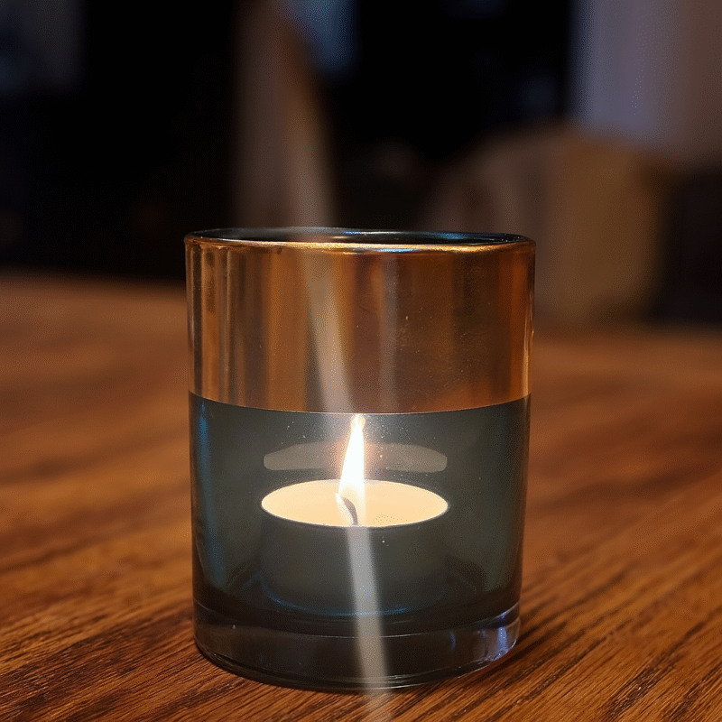 En stilren och stämningsfull ljuslykta där färgat glas möter elegant guldkant. En liten men effektfull detalj. Diameter 7 cm, höjd 8 cm.