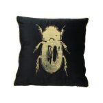 Kudde i svart textil med guldtryck. Levereras komplett med innerkudde. Mått 50x50 cm.