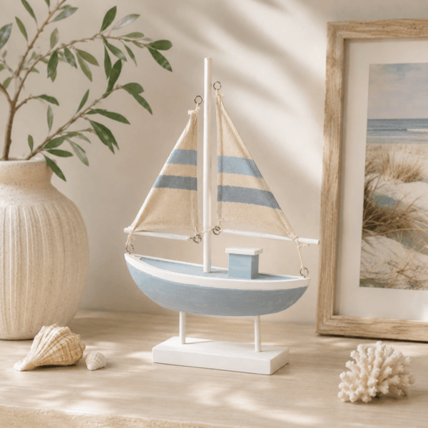 Dekorativ segelbåt i trä och textil i mjuka marina toner. Skapa en kustnära och harmonisk känsla i hemmet med maritim charm.