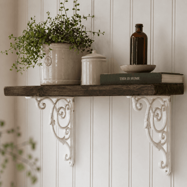 Hyllkonsol i vitmålat gjutjärn 22×18 cm med ornamenterat mönster. Stabil och dekorativ konsol som passar perfekt till hyllplan i trä.