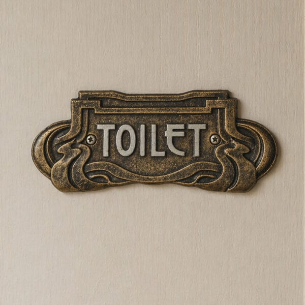 Toalettskylt i bemålat gjutjärn i dekorativ Art Nouveau stil. Stilfull och tydlig skylt 18,5x7,5 cm som ger dörren ett genomarbetat uttryck.