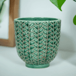 Kruka i petrolfärgat stengods med dekorativt mönster. Diameter 11 cm, höjd 11 cm.