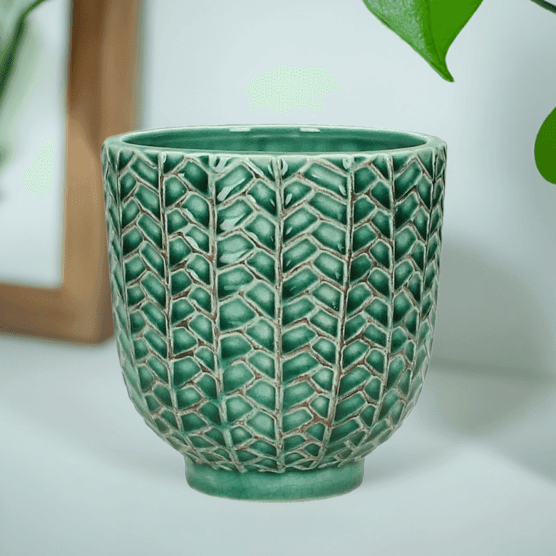 Kruka i petrolfärgat stengods med dekorativt mönster. Diameter 11 cm, höjd 11 cm.