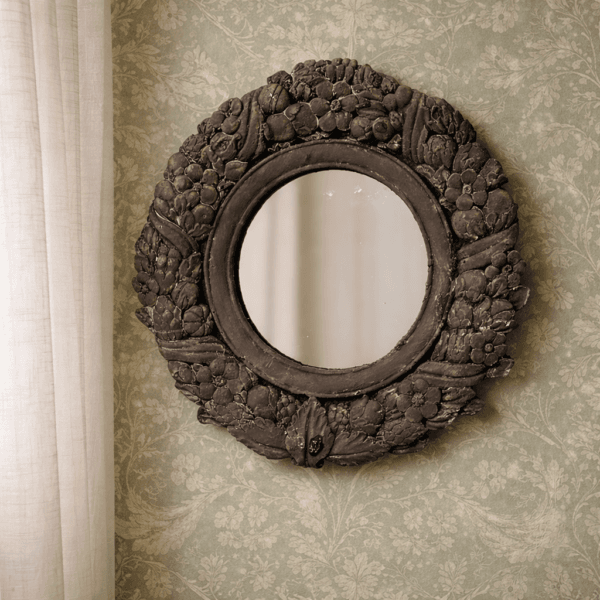 Dekorativ spegel i polystone med matt yta och detaljrik relief. Ett uttrycksfullt inslag som passar fint både ensam och i kombination med andra objekt.