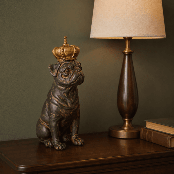 Ståtlig hundfigur med krona i antikbehandlad brun polyresin. En charmig och humoristisk dekoration för hyllan, skänken eller byrån. Höjd 29 cm.