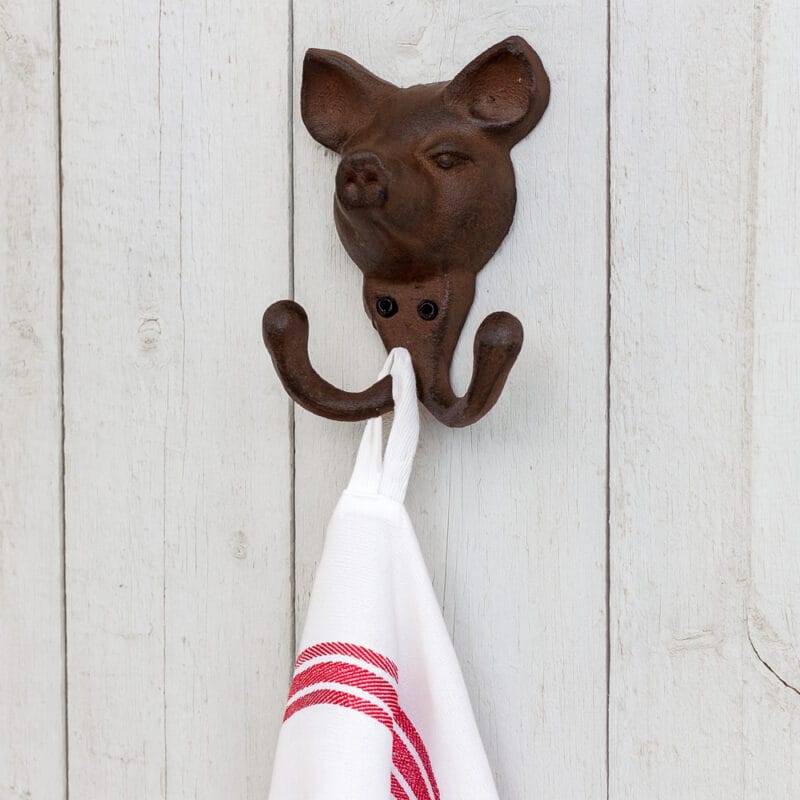 Dubbelkrok i gjutjärn med dekor av gris. Mått 10x9,5x4 cm (hxbxd).