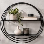 Rund vägghylla i svart metall med två hyllplan. Stilren och grafisk design som passar för böcker, växter och dekor. Diameter 48 cm.