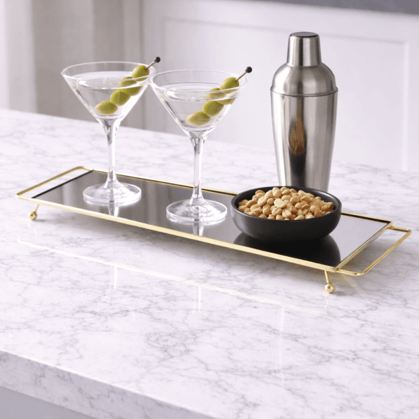 Elegant bricka i guldfärgad metall med spegelglas. Smäcker design med tunna detaljer, perfekt för servering eller som stilren inredningsdetalj.