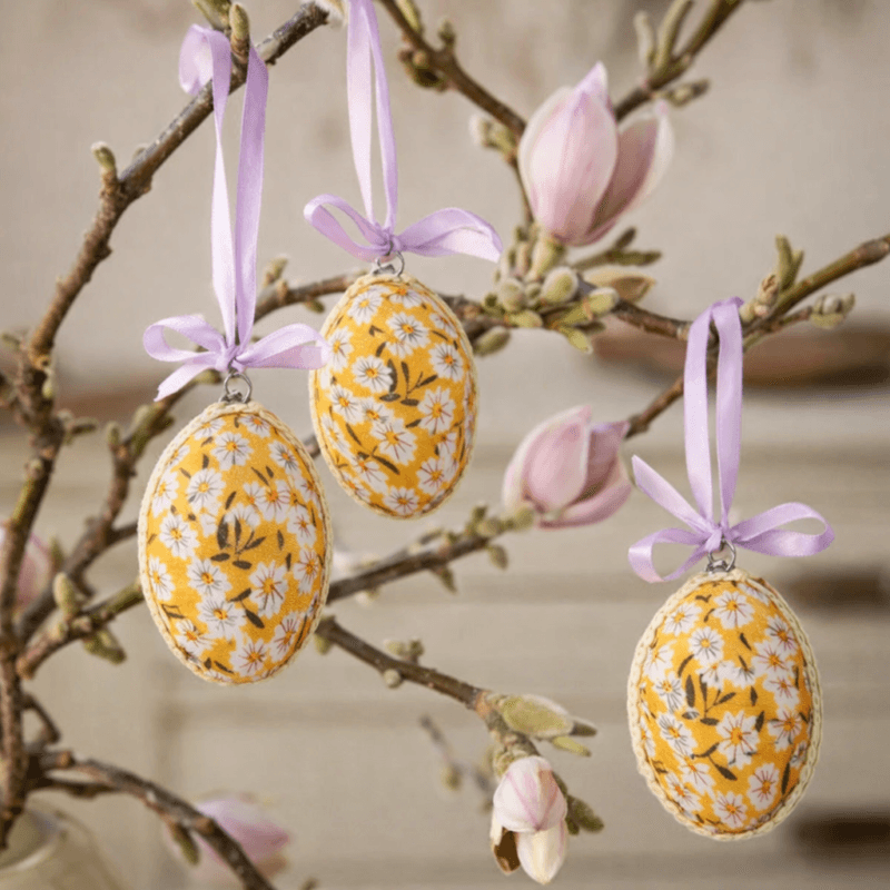 Set med 4 dekorativa påskägg i gult tyg med blommönster. 6 cm långa, perfekta i björkris och vårarrangemang. Ger en glad och ljus vårkänsla.