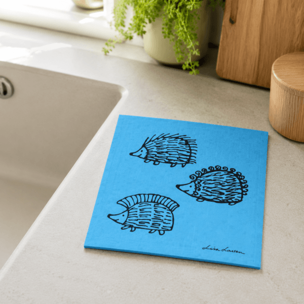 Blå disktrasa i Wettex med Lisa Larsons igelkottar Iggy, Piggy och Punky. Tvättbar i både disk- och tvättmaskin för enkel rengöring. Mått 20 × 17 cm.