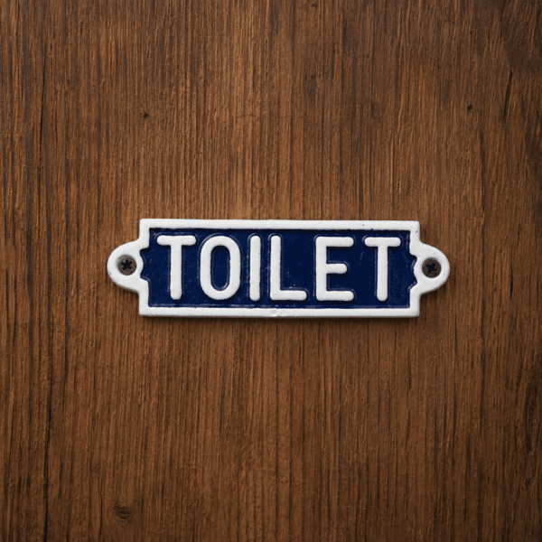 Skylt i gjutjärn med texten TOILET. En tydlig och dekorativ detalj för badrumsdörr eller gästtoalett med klassisk stil och hållbar känsla.