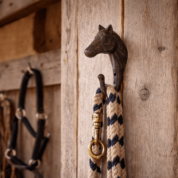 Gjutjärnskrok med hästhuvud som kombinerar funktion med en rustik, lantlig känsla. En dekorativ detalj som passar fint i både stall och hem.