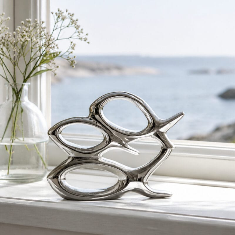 Dekorativa fiskar i silverfärgad keramik med maritim känsla. Fin inredningsdetalj för hylla, fönster eller badrum. Mått 19x5x14 cm.