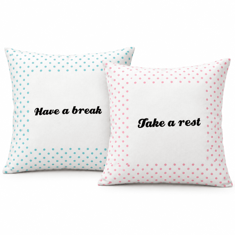 Två vita kuddfodral med rosa och turkosa prickar och svart text, 40×40 cm