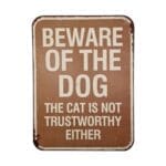 Humoristisk plåtskylt med texten "Beware Of The Dog - The Cat Is Not Trustworthy Either". Perfekt för djurälskare och som rolig dekoration. Mått 33x25 cm