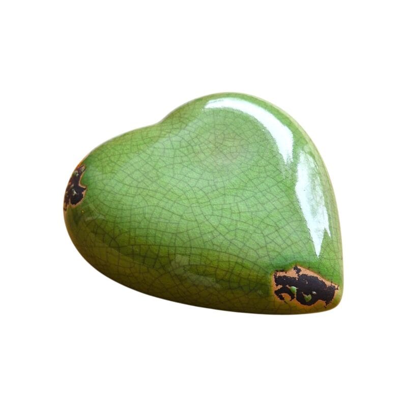Dekorativt hjärta i keramik med krackelerad grön glasyr och blank yta. Vacker inredningsdetalj för hylla eller fönster. Mått 16x15x6 cm. Perfekt för ett personligt hem.