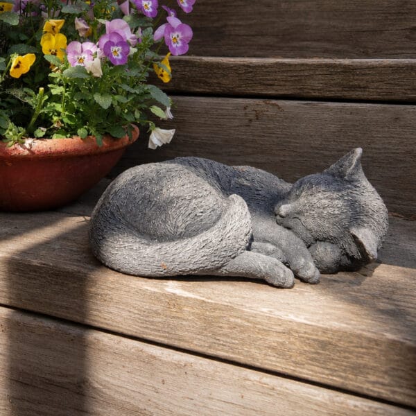 Handgjuten katt i betong med naturtroget formade detaljer som ger den sovande katten ett levande uttryck. En tidlös dekoration för trädgård och hem.