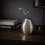 En dekorativ vas i keramik i en snygg silvermetallic nyans. Vasen har ett mönster och en form som ger den ett levande och unikt uttryck.