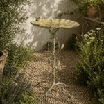 Fågelbad i metall med bladformat fat och dekorativt stativ. Höjd 77 cm. En elegant trädgårdsdetalj som ger liv och rörelse till utemiljön.