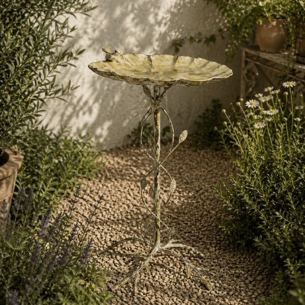 Fågelbad i metall med bladformat fat och dekorativt stativ. Höjd 77 cm. En elegant trädgårdsdetalj som ger liv och rörelse till utemiljön.