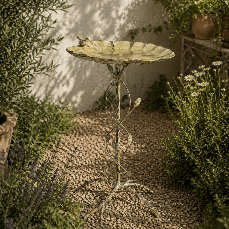 Fågelbad i metall med bladformat fat och dekorativt stativ. Höjd 77 cm. En elegant trädgårdsdetalj som ger liv och rörelse till utemiljön.