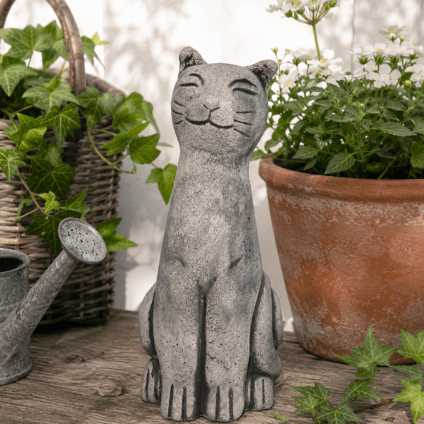 Handgjuten katt i betong 29 cm med rofyllt leende och vacker betongyta. En dekorativ trädgårdsfigur som passar lika fint vid entrén som på altanen.