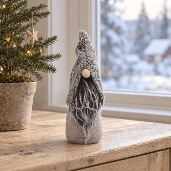 Grå textiltomte på träskänk i vintermiljö