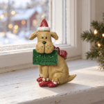 Julhund med tomteluva och Merry Christmas-skylt i ljus julmiljö vid fönster