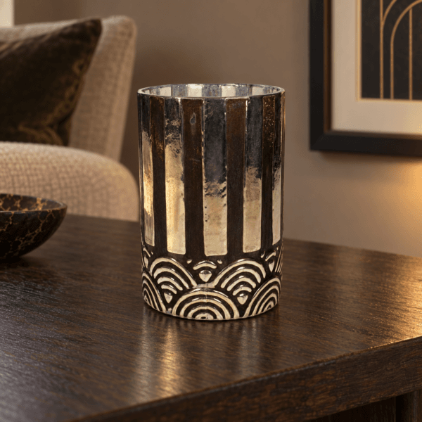 Ljuslykta i glas med Art Deco-mönster på mörkt träbord