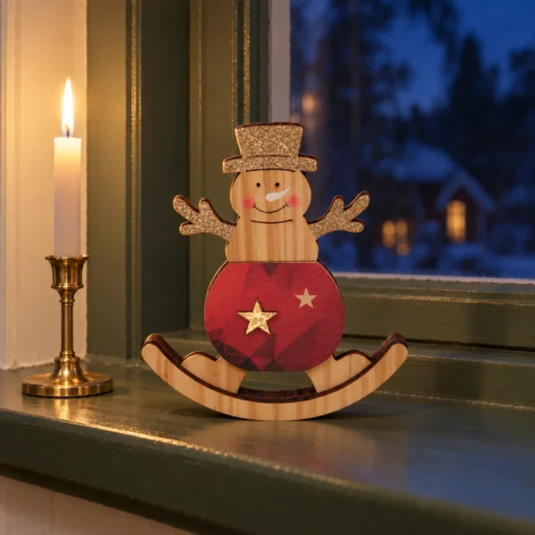 Snögubbe i trä med röd kropp och glittrande hatt på en grön fönsterbräda bredvid en mässingsljusstake.