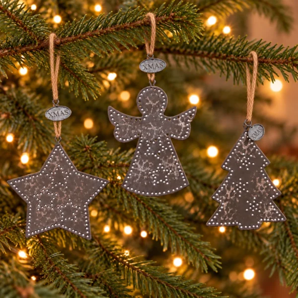 Stjärna, ängel och gran i mörk metall med XMAS-brickor hänger i snören runt julgranens grenar.